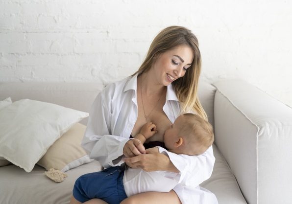 medium-shot-happy-woman-breastfeeding-her-baby_23-2148254038